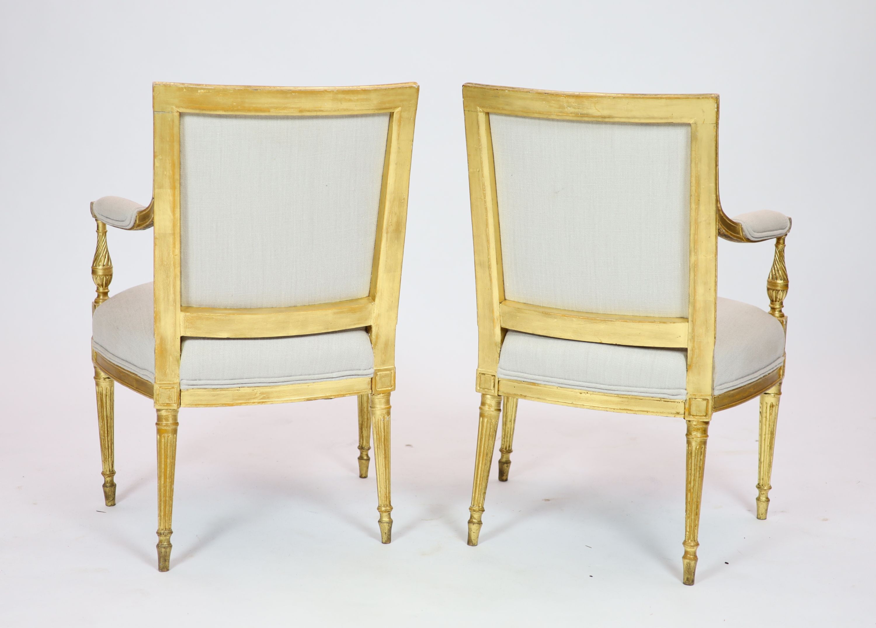 A pair of Louis XVI style giltwood elbow chairs H 89cm. W 59cm. D 60cm.